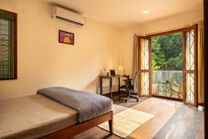 a bedroom with a bed and a desk and a window at LiveAway Bengaluru, HSR by PACK in Bangalore
