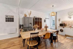 a kitchen and dining room with a wooden table and chairs at Le Cocon d'Eymet village in Eymet