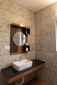 a bathroom with a sink and a mirror at Kerala cottage in Varkala