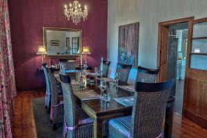 a dining room with a long wooden table and chairs at Maison Fougere in Franschhoek