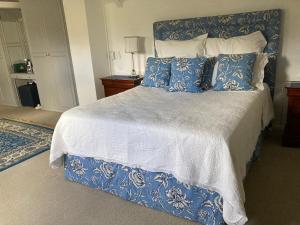 a bedroom with a blue and white bed with pillows at Maison Fougere in Franschhoek
