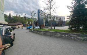 a parking lot with cars parked next to a building at Montain apartament in Brezoi +13 photos