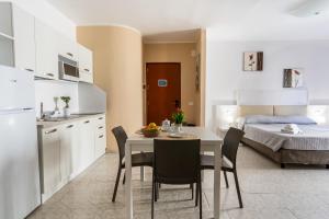a kitchen and dining room with a table and a bed at Rina Sea Apartments in Alghero +11 photos