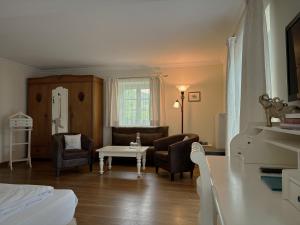 a living room with a bed and a table and chairs at Landhaus Marinella Hotel Garni in Bad Wiessee