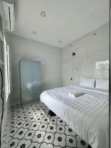 a bedroom with a large bed with a black and white floor at Bắp Bơ Homestay in Cồn Giả Viên