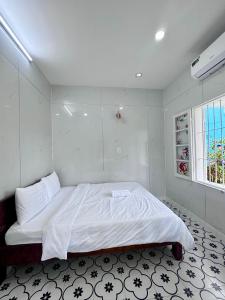 a bedroom with a large bed with white sheets at Bắp Bơ Homestay in Cồn Giả Viên +3 photos