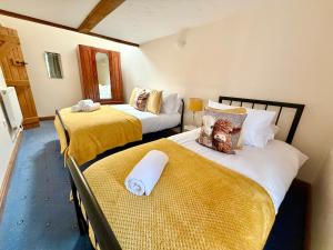a bedroom with two beds with yellow sheets at Very spacious rural 2 bed barn sleeps 5 in Usk