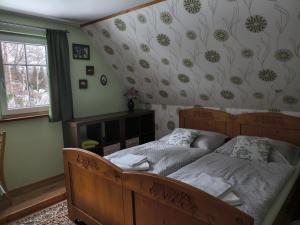 a bedroom with a wooden bed and a fireplace at Chalupa pod smrky in Bedřichov