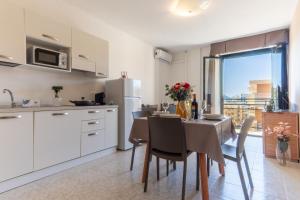 a kitchen and dining room with a table and chairs at Rina Sea Apartments in Alghero