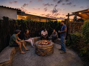 a group of people sitting around a fire pit at Luxury Backpackers in Port Elizabeth