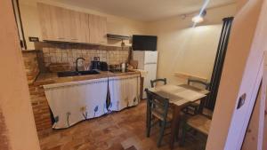 a small kitchen with a counter and a table with chairs at B&B XXIV Maggio in Rocca di Botte