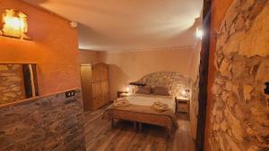 a bedroom with a bed and a stone wall at B&B XXIV Maggio in Rocca di Botte