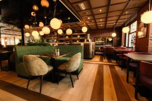 a restaurant with a green table and chairs at De Herbergh van Flielant in Oost-Vlieland