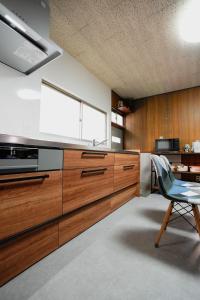 a kitchen with wooden cabinets and a blue chair at 碧 AO Antik&Bay in Takamatsu