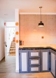 a kitchen with a blue cabinet and a staircase at Salty Life Surf House in Imsouane