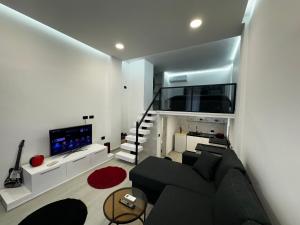 a living room with a black couch and a tv at Vila Calm in Pogradec