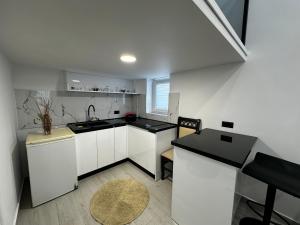 a kitchen with white cabinets and a black counter top at Vila Calm in Pogradec