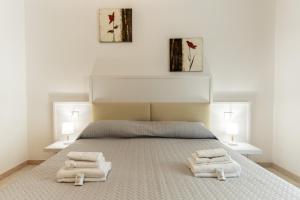 a bedroom with a bed with two towels on it at Rina Sea Apartments in Alghero