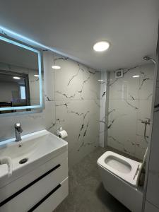 a white bathroom with a sink and a toilet at Vila Calm in Pogradec +15 photos