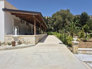 a walkway in front of a building with trees at Blu In in Palma di Montechiaro