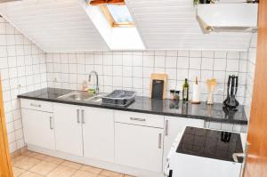 a kitchen with white cabinets and a sink at Le Nid, Duplex lumineux proche Colmar in Soultz-Haut-Rhin