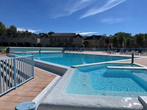 a large swimming pool with blue water at Lake view Appartment in Monflanquin +11 photos