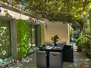 a table with chairs and a vase on a patio at Villa La Marpierre in Mondragon