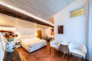 a bedroom with a bed and chairs in a room at Palazzo Rivola in Bergamo