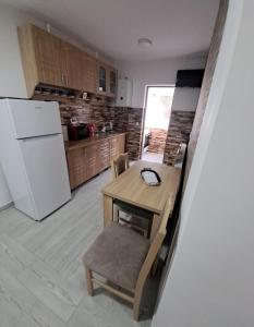 a kitchen with a table and a white refrigerator at Montain apartament in Brezoi