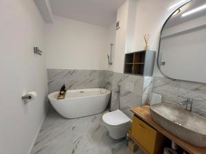 a bathroom with a tub and a toilet and a sink at DaVinci Apartments VRT in Cristian