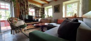 a living room with a couch and a tv at Chalupa pod smrky in Bedřichov