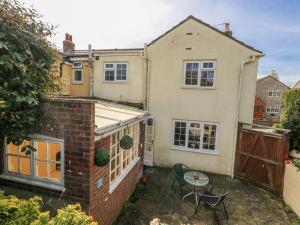 an apartment with a small patio with a table and chairs at September Cottage in Weymouth