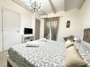 a bedroom with a large bed and a television at Sicilia Meraviglia B&B in Fontane Bianche