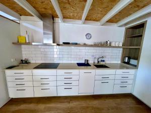a kitchen with white cabinets and a sink at Casa a 20 minuts de Barcelona in Molins de Rei +13 photos