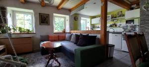 a living room with a couch and a kitchen at Chalupa pod smrky in Bedřichov