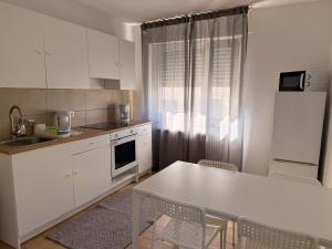 a kitchen with white cabinets and a table and chairs at Ferienwohnung Landskrone in Oppenheim