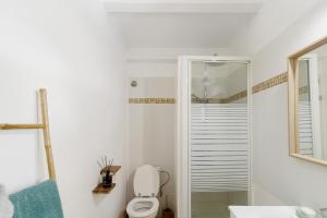 a white bathroom with a toilet and a shower at Mer et montagne à Conca in Conca +13 photos
