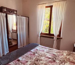 a bedroom with a bed and a large window at Antica Fiera in Caprese Michelangelo