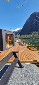 a house with a wooden deck with mountains in the background at Olden Camping in Olden +88 photos