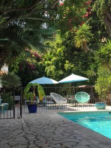 a swimming pool with chairs and umbrellas next to at Le Val Duchesse Hotel & Appartements in Cagnes-sur-Mer