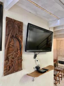 a flat screen tv hanging on a wall at Maré Alta 400 mt da praia de Maresias in Maresias