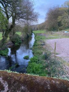 a river in a field next to a fence at The Stables Apartment in Midleton