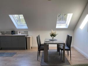 a dining room with a table and chairs and skylights at The Stables Apartment in Midleton