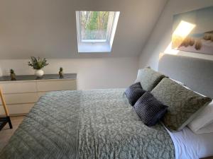 a bedroom with a bed with two pillows and a window at The Stables Apartment in Midleton