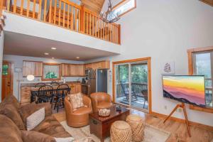 a living room with a couch and a tv and a kitchen at Above It All in Townsend