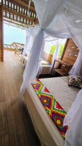 a bedroom with two beds with a canopy at cabaña malambo in Termales - agua caliente - nuqui