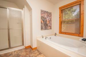 a white bathroom with a tub and a window at Above It All in Townsend +27 photos