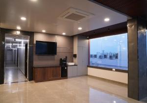 a lobby with a flat screen tv and a large window at Sri Rama Grand in Chilakalūrupet