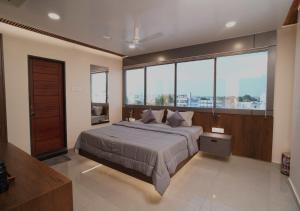 a bedroom with a large bed and large windows at Sri Rama Grand in Chilakalūrupet