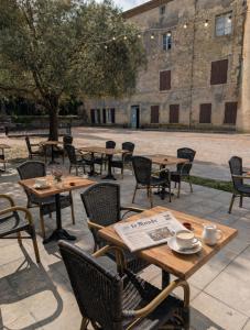 a group of tables and chairs in front of a building at Les Chambres Cast'elles in Malves